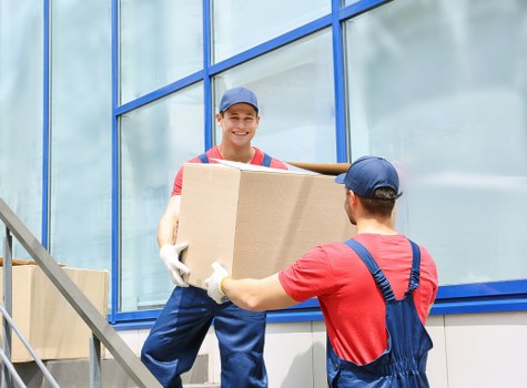 Local movers carrying furniture carefully through a residential property